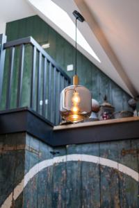 een glazen hanglamp die aan een trap hangt bij B&B Lindehoeve Texel in Den Hoorn
