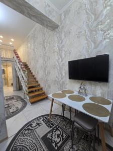 a living room with a table and a tv on a wall at BURABAY Promenade Solo in Borovoye