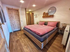 een slaapkamer met een groot bed met een spiegel aan de muur bij Landhaus Speiser in Bolsterlang