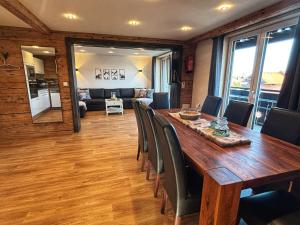 een eetkamer met een lange houten tafel en stoelen bij Landhaus Speiser in Bolsterlang