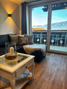 een woonkamer met een bank en een groot raam bij Landhaus Speiser in Bolsterlang