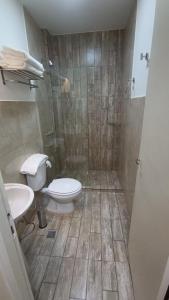 a bathroom with a toilet and a sink and a shower at Hotel Boutique Porá Iguazú in Puerto Iguazú
