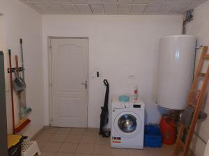 een wasruimte met een wasmachine en een deur bij Maison 400m de la mer in Pénestin