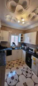 a kitchen with white cabinets and a tile floor at BTourays Rentals in Yundum
