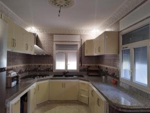 a kitchen with white cabinets and granite counter tops at Luxurious mountain villa avec wifi in El Ksiba