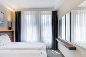 Postel nebo postele na pokoji v ubytování Regnum Bansko Ski Hotel & SPA