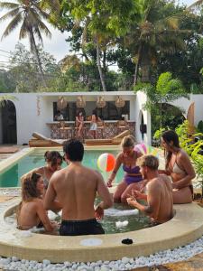 a group of people sitting around a swimming pool at Casa Carmen Hostel in Weligama