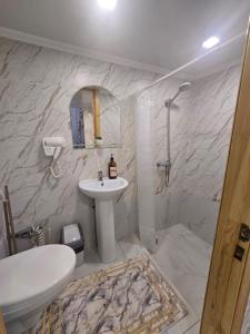 a white bathroom with a sink and a shower at BURABAY Promenade Solo in Borovoye