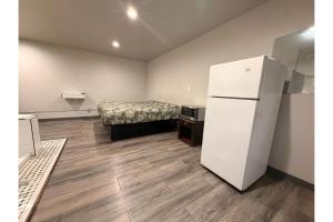 a room with a refrigerator and a bed in it at The Queen B Motel, Detroit-Warren in Warren