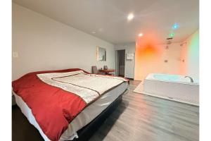 a bedroom with a bed and a bath tub at The Queen B Motel, Detroit-Warren in Warren