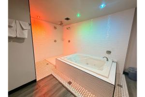 a bathroom with a tub in the middle of it at The Queen B Motel, Detroit-Warren in Warren +25 photos