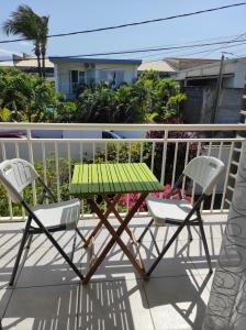 a green table and two chairs on a balcony at Combava in Saint-Pierre +4 photos
