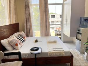 een bed in een kamer met een groot raam bij Hosting by Vee in Mtwapa