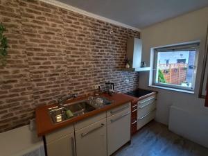 a kitchen with a brick wall and a sink at NordseeNest Varel in Varel +19 photos