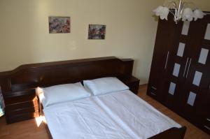 een bed met een houten hoofdeinde in een slaapkamer bij Der Zesch in Schrattenberg