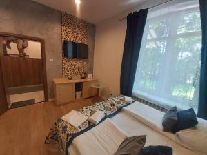 a bedroom with two beds and a large window at Dworek Zakopane in Zakopane