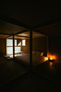 a dark room with a bed with a candle on it at A&A Okayama in Okayama