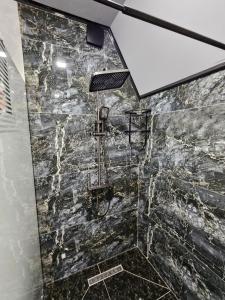 a bathroom with a shower with a stone wall at AFrame Shahdag in Qusar +14 photos