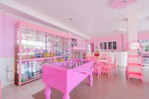 una stanza rosa con un tavolo e sedie rosa di บ้านพวงชมพูเกาะล้าน a Ko Larn