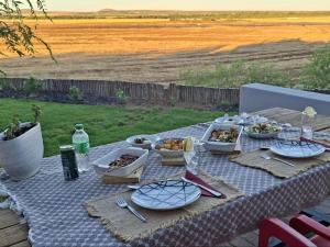 a picnic table with plates and bowls of food on it at Leopolds Rest in Prieska +2 photos