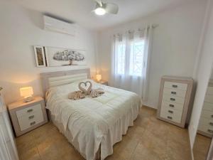 a bedroom with a bed with a bow on it at La Casa de Torrevieja in Torrevieja +33 photos