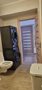 een badkamer met een toilet en een deur naar een kamer bij Goldmaurer in Târgu-Mureş +32 foto's