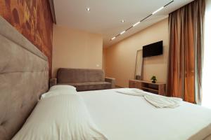 a hotel room with a bed and a chair at Central Rooms in Shkodër +12 photos