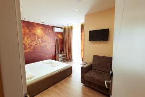 a hotel room with a bed and a chair at Central Rooms in Shkodër