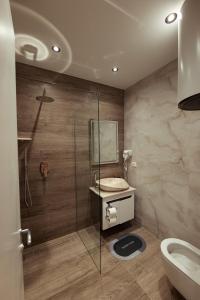 a bathroom with a shower and a sink and a toilet at Central Rooms in Shkodër