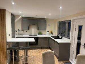 a kitchen with gray cabinets and white counter tops at Caledonian Lock House in Caol +13 photos