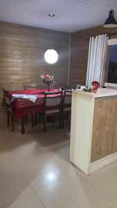 a dining room with a red table with chairs and a tableablish at Casa praia in Capão da Canoa