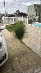 a car parked next to a white fence at Casa praia in Capão da Canoa