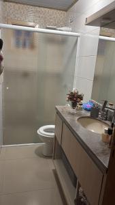 a bathroom with a shower and a toilet and a sink at Casa praia in Capão da Canoa