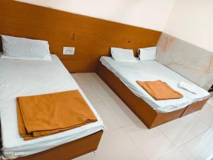 two beds in a small room with at RK Hotel in Boisar +9 photos