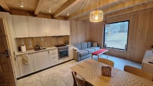 a kitchen with white cabinets and a table and a dining room at Siedlisko Gruszeczki in Gruszki