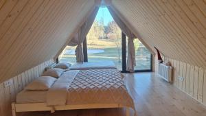 a large bed in a room with a large window at Siedlisko Gruszeczki in Gruszki