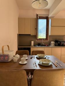 a kitchen with a wooden table with chairs and a dining room at Marathias Home in Leonidion