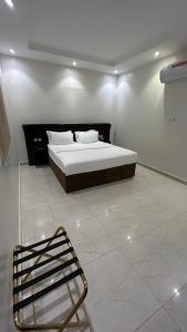 a bedroom with a bed and a chair in it at شقق درةراشد للشقق المخدومة in Hafr Al-Batin