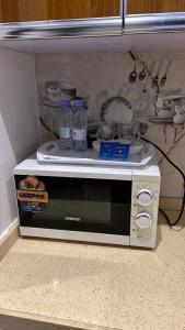 a microwave oven sitting on a kitchen floor at شقق درةراشد للشقق المخدومة in Hafr Al-Batin