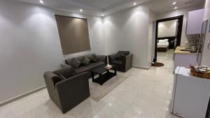 a living room with two couches and a kitchen at شقق درةراشد للشقق المخدومة in Hafr Al-Batin