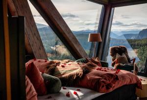 a bed in a room with a large window at Eagle Nest Eco Lodge in Sel