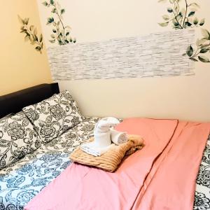 a bed with a towel and a stuffed animal on a blanket at Dvine Era Staycation in Manila +12 photos
