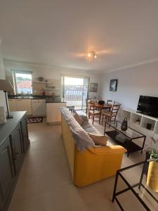 a living room with a yellow couch and a table at Sunset Paradise in Caminha