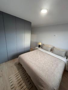 a bedroom with a large white bed and a lamp at Sunset Paradise in Caminha