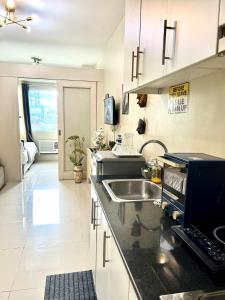 a kitchen with a sink and a counter top at Dvine Era Staycation in Manila +12 photos