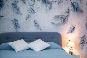 a bedroom with a mural of feathers on the wall at Casa Yuliya 11 in Como