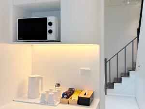 a living room with a tv on a wall at Bedd Hostel in Bangkok