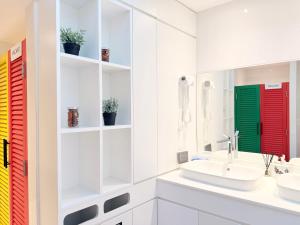 a white bathroom with a sink and a mirror at Bedd Hostel in Bangkok +29 photos