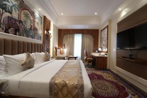 a hotel room with a bed and a desk at Hotel Maharaja Palace Rohtak in Kahrāwar