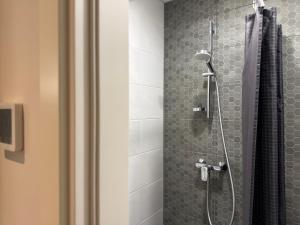 a bathroom with a shower with a glass door at Stylish smart studio in Tallinn +65 photos